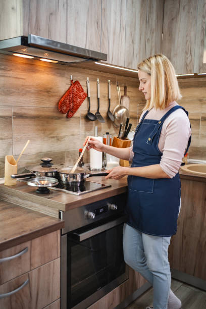 istock Woman cooking in modern kitchen using induction stove 2197056754