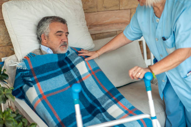istock Nurse caring for elderly man covered with blanket in wheelchair 2197057033