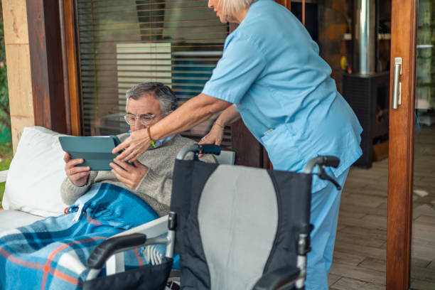 istock Nurse assisting senior man using digital tablet in wheelchair on the terrace 2197057249