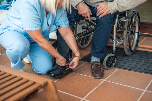 istock Nurse helping senior man with walking boot and wheelchair 2197057347