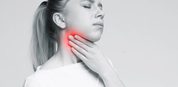 istock Woman suffering with sore throat, touching her neck 2197058323
