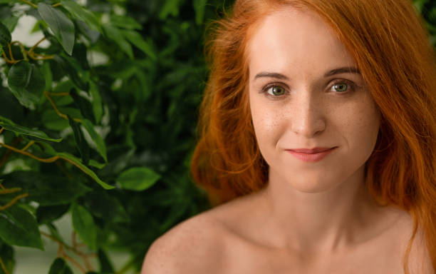 istock Young redhead woman touching her face, green background 2197058626