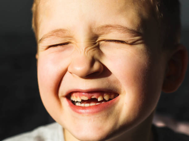 istock boy's face smiling with baby teeth close up 2197059891