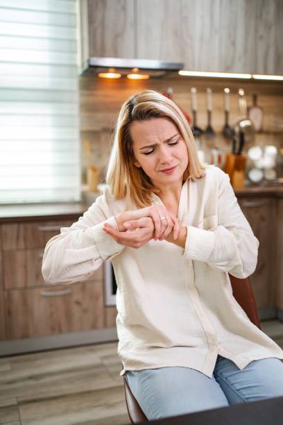 istock Woman experiencing wrist pain while sitting in the kitchen 2197060245