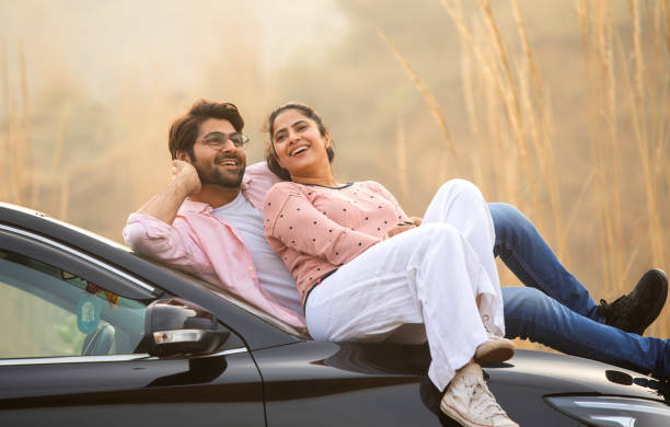 istock Loving couple looking at each other while relaxing on car 2197062052