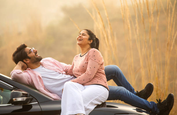istock Loving couple looking at each other while relaxing on car 2197062105