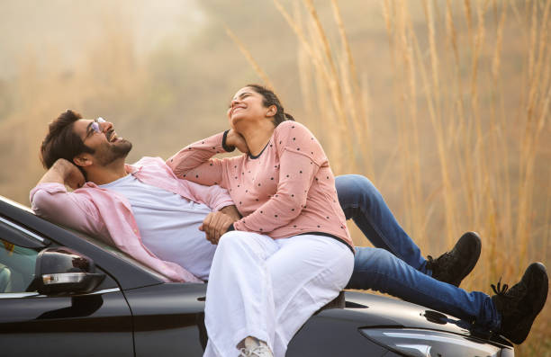 istock Loving couple looking at each other while relaxing on car 2197062129