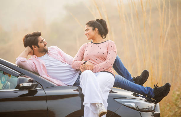istock Loving couple looking at each other while relaxing on car 2197062241