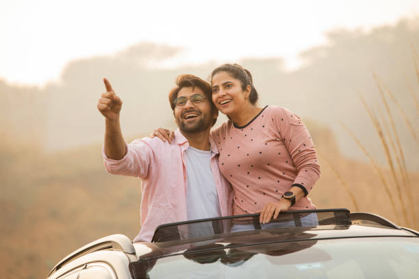 istock Carefree couple pointing through car sun roof 2197062406