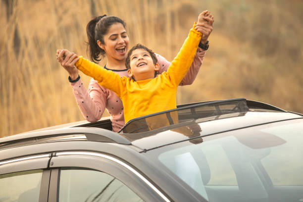 istock Mother and son enjoying road trip while looking through sun roof 2197063301