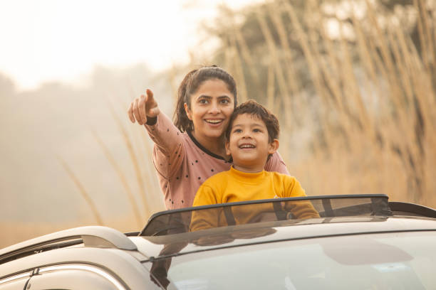 istock Mother and son enjoying road trip while looking through sun roof 2197063315