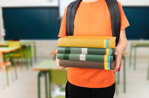 student boy suffering from a broken hand in a cast and sitting at the school desk