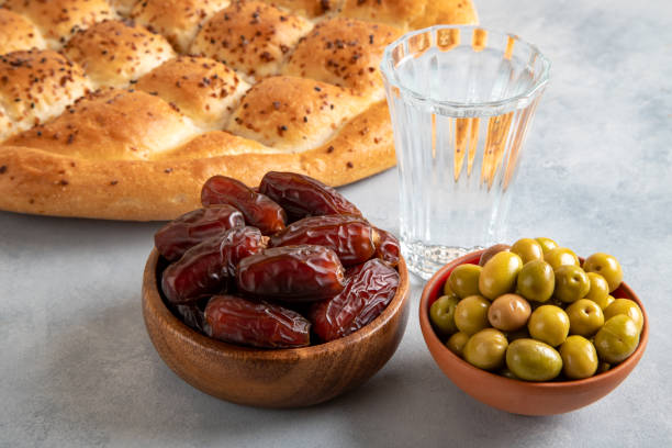 istock Dates fruit, green olives, Ramadan pita, and water for the iftar table 2197071868