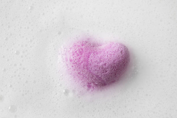 Valentine's Day heart shaped bathtub salt in white foam as background.