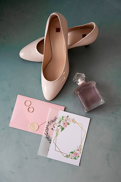 istock Wedding shoes, perfume, rings, and invitation on a soft green background 2197073198