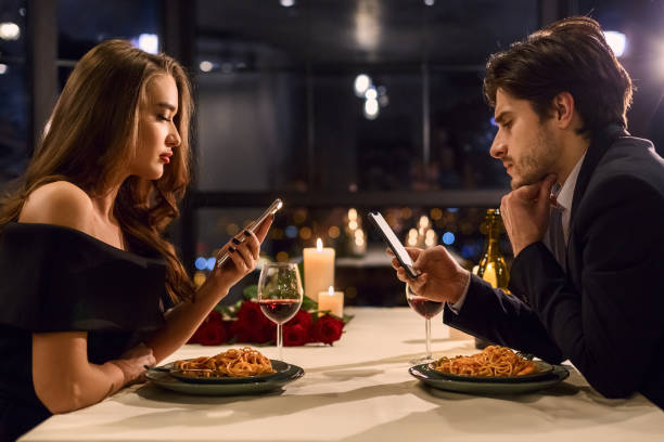 istock Couple using smartphones in restaurant 2197080889