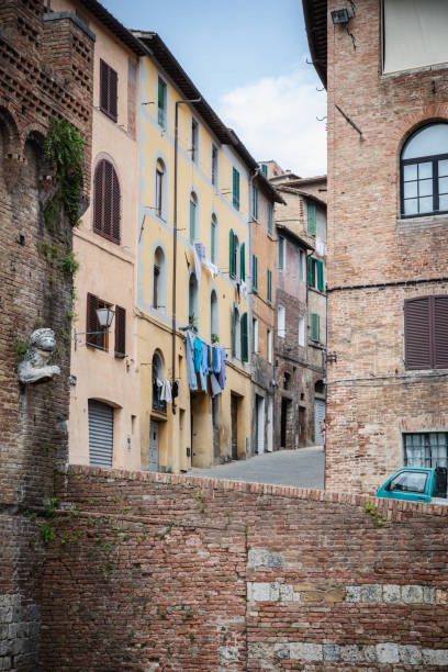 Timeless Siena—where history meets daily life. Old-world charm and modern rhythms blend as colorful clothes sway on lines above the narrow streets, framed by centuries-old architecture.