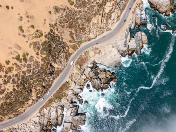 istock Aerial View: Coastal Road Winding Above Rocky Shoreline 2197082113