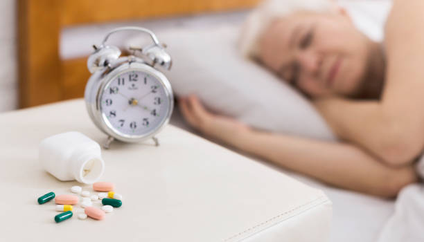 istock Senior woman sleeping in bed with help of pills 2197082362