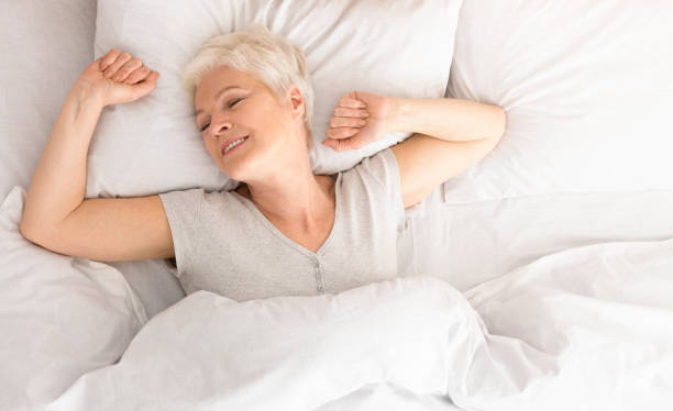 istock Senior woman lying down in her bed at home 2197082374