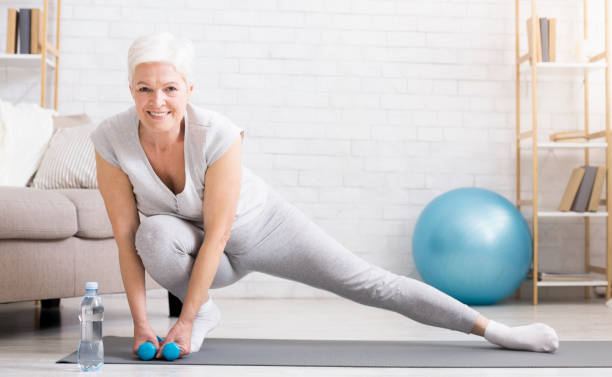 istock Active senior woman doing exercises at home 2197082377