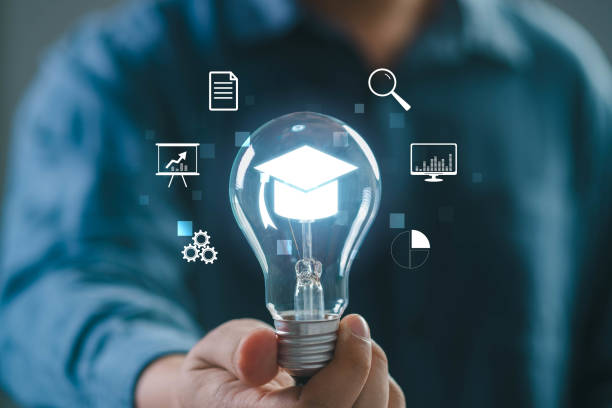 istock A person holds a glowing light bulb symbolizing innovation, education, and digital technology in a vibrant workspace. 2197083885