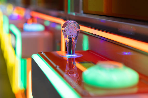 A neon green and purple button with a glass knob on top. A claw machine controller.