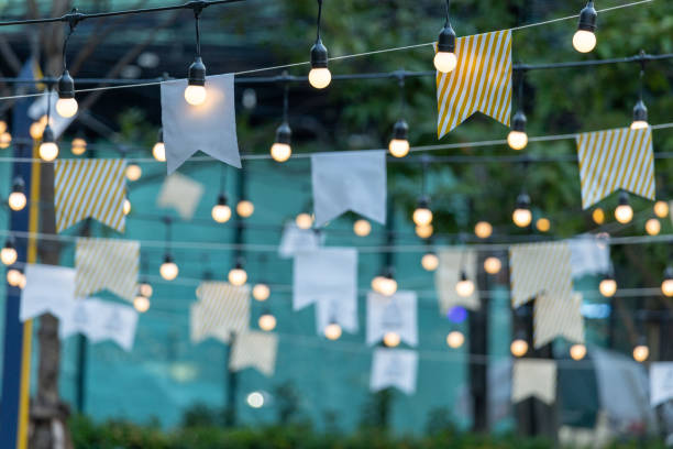 A string of lights with white and yellow flags hanging from them