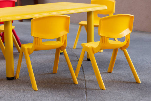 istock A yellow plastic kid chair sits next to another yellow plastic chair 2197085738