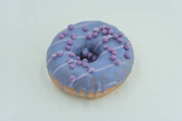 istock A centered image showcases a single donut with light purple glaze and evenly distributed decorations, possibly sprinkles or sugar beads The background is subtle 2197088181