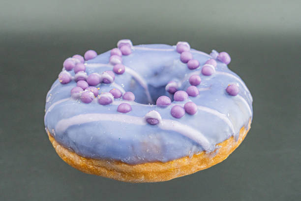 istock A glazed doughnut with purple sprinkles stands out against a light background in this straightforward photograph 2197088231