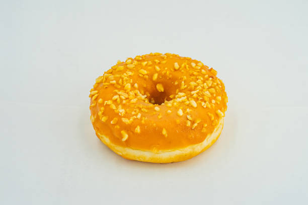 istock A single, golden brown doughnut with sesame seeds on a light background 2197088235