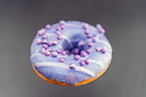 istock A purple-glazed doughnut stands out against a neutral background in the image, showcasing texture and depth 2197088245