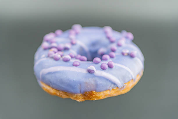 istock A central, single purple-glazed doughnut with white specks on a grey background The doughnut appears to be deep-fried and possibly lavender-flavored 2197088247