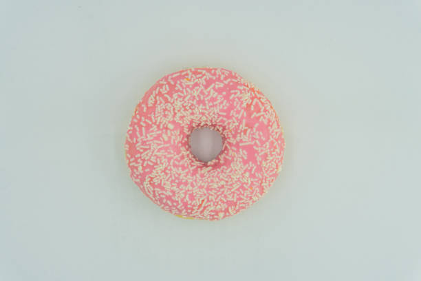 istock A centered, slightly angled doughnut with pink glaze and sprinkles on a light surface No distractions in the simple composition 2197088275