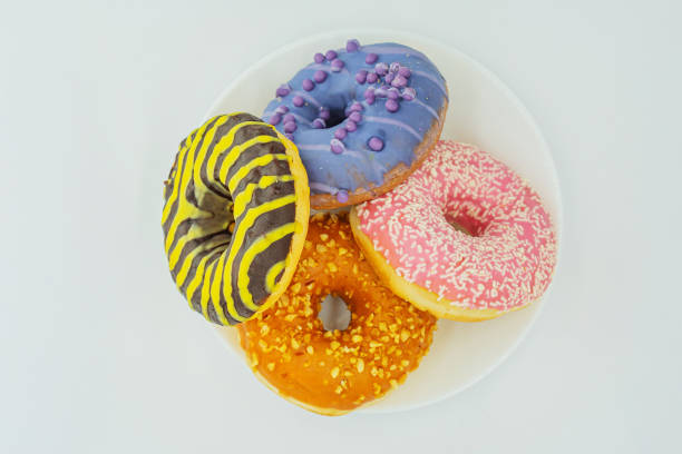 istock Six colorful doughnuts with varying sprinkle toppings arranged on a white surface 2197088331