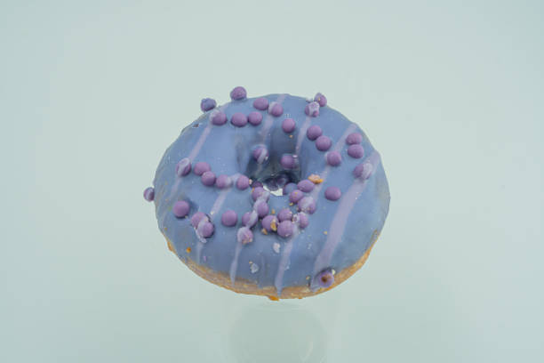 istock A vibrant, glossy blue glazed doughnut with decorative dark sprinkles on the upper half is shown against a neutral backdrop in a simple photograph 2197088568