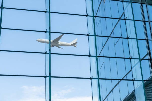 istock airplane fly over modern office buildings from low angle view. 2197098488
