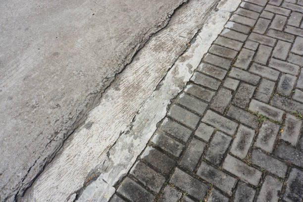Close-Up of Cracked Road Surface Joining Brick Pavement