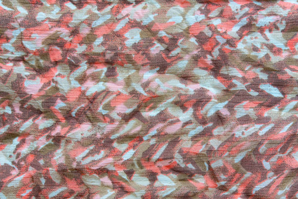 istock Colorful camouflage fabric background showing wrinkled textile 2197100898