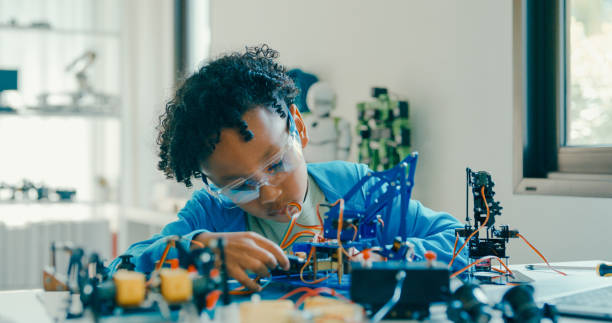 istock Young African-American boy in STEM education by assembling robot at home. STEM Education robotics courses online. 2197102672