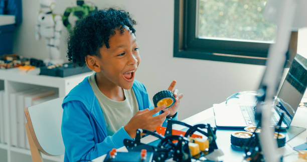 istock Young African-American boy in STEM education by assembling robot at home. STEM Education robotics courses online. 2197102698