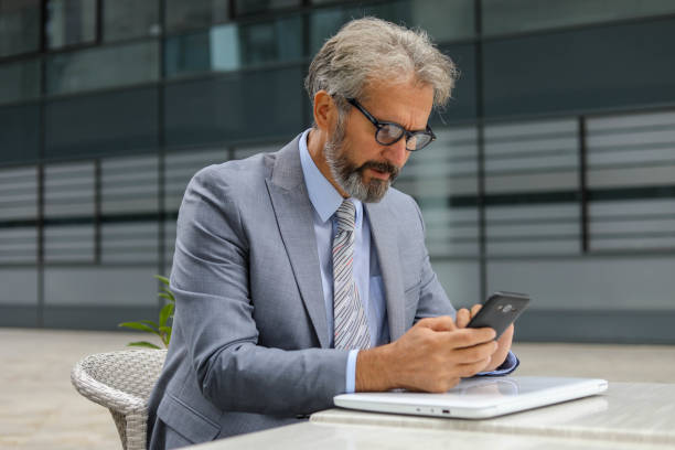 istock Business Man Using His Cell Phone On The Street 2197104576