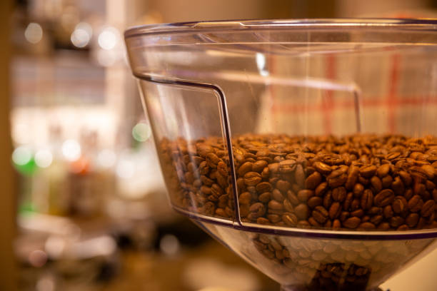 Put coffee beans with the dark background in words OPEN shop with coffee barista and coffee maker.