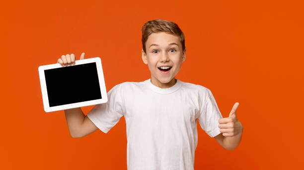 istock Teenage boy showing blank digital tablet screen 2197107479