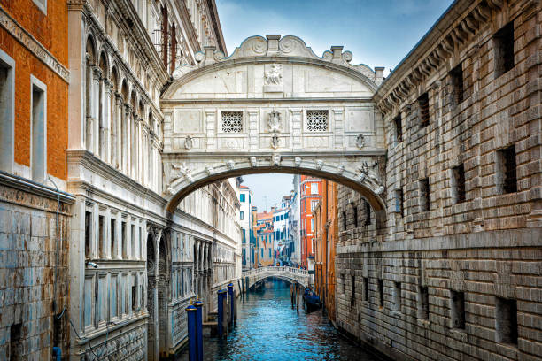 The image depicts the Bridge of Sighs in Venice, Italy, showcasing its distinctive architecture and the canal below. The bridge connects the Doge's Palace to a historic prison, highlighting the city's rich cultural heritage. The scene captures the interplay of light and reflections in the water.