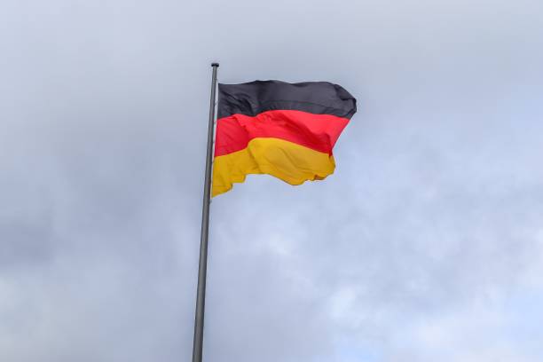 istock German flag waving on a cloudy sky background 2197111612