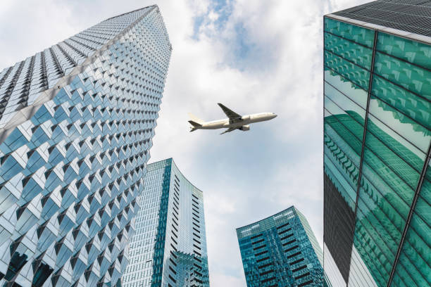 istock airplane fly over modern office buildings from low angle view. 2197111622