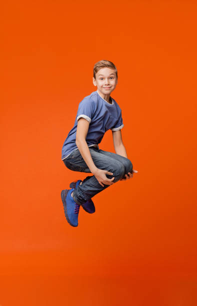 istock Cheerful school boy jumping in bomb style 2197112047