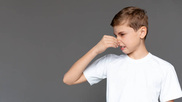 istock Child Making a Disgusted Face While Pinching Nose, Expressing Distaste in a Neutral Setting 2197112140